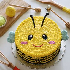 a yellow cake decorated with an image of a smiling bee on it's face