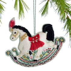 a christmas ornament with a horse on it hanging from a pine tree branch