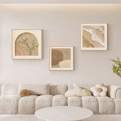 a living room filled with white furniture and pictures on the wall above it's couch