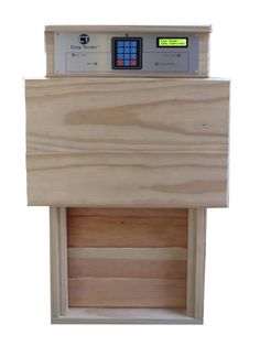 a wooden box with a calculator in it's center and electronic buttons on the lid