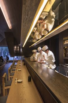 the chefs are preparing their meals in the large kitchen at the restaurant's counter