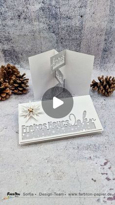 a christmas card with pine cones next to it