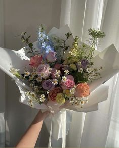 a bouquet of flowers is being held by someone