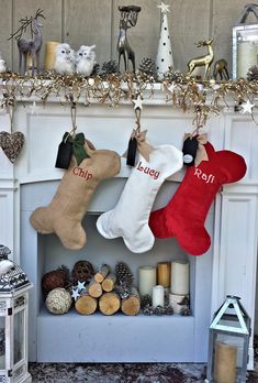 stockings hung on the mantel in front of a fireplace with christmas decorations and candles