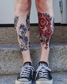 a woman's legs with tattoos and flowers on them, sitting on the steps