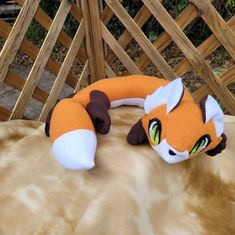 an orange and white stuffed animal laying on top of a bed