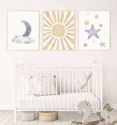 a baby's room with two paintings on the wall and a rocking horse in the foreground