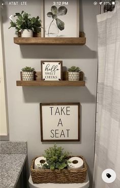 a bathroom with two shelves above the toilet and some plants on top of the shelf