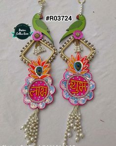 pair of colorful earrings with bird and flower design on each earring, hanging from gold plated chain