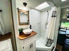 a bathroom with a sink, mirror and bathtub in the shower area is shown