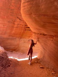 a woman standing in the middle of a canyon