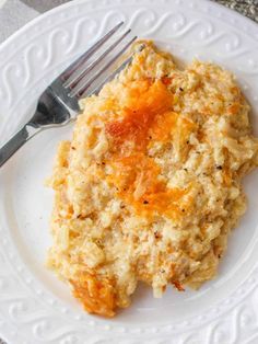 a white plate topped with mashed potatoes and carrots next to a silver fork