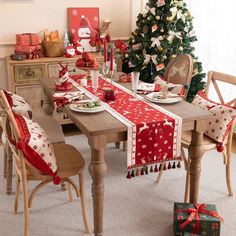 a dining room table decorated for christmas with presents