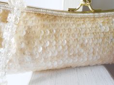 "Sparkly cream beaded evening bag. This bag really sparkles. The La Regale bag is covered with sequins and beads in a creamy pearly color. It has a goldtone frame and a kiss lock. The interior of the bag is cream satin and it contains one pocket. This is a beaded clutch handbag plus it has a short bead handle.A very glamorous evening bag that you will use for many occasions. A very neutral color. MATERIAL: Beads and sequins CONDITION: It is in good condition SIZE: It measures 10.5\" wide and 4\" White Sequined Bags For Wedding, White Sequin Bag For Wedding, White Sequined Wedding Bag, Cream Evening Bag With Pearl Embroidery For Wedding, Beige Pearl Evening Bag For Wedding, Beige Pearl Embellished Evening Bag For Wedding, Embellished Cream Evening Bag For Wedding, Beige Pearl Embroidered Evening Bag For Wedding, Cream Pearl Wedding Bag