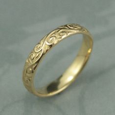 a yellow gold wedding ring with an intricate design