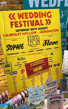 a poster for the wedding festival on display at a vendor's booth in front of a brick wall