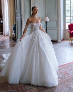 a woman in a white wedding dress is posing for the camera