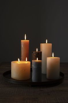 five lit candles sitting on top of a wooden table