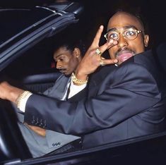 a man sitting in a car making the peace sign