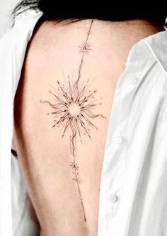 the back of a woman's neck with a sunflower tattoo on it