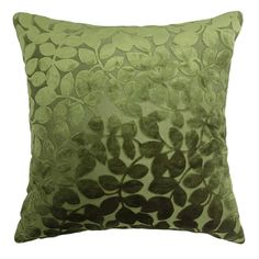 a green and black pillow with leaves on it