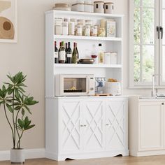 a kitchen with white cupboards and shelves filled with bottles, wine glasses, and other items