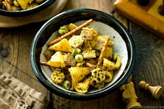 two bowls filled with food on top of a wooden table