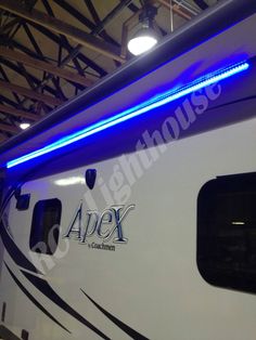 the side of a train with blue lights on it's windows and an adex logo