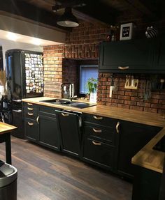 a kitchen with wooden floors and black cabinets