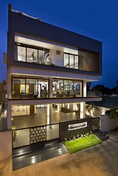 a large modern house at night with its lights on