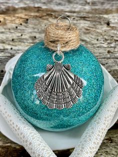 a blue ornament with a seashell on it sitting on a white plate