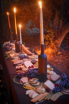 a table topped with cheese, crackers and candles