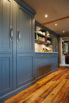 a kitchen with blue cabinets and wooden floors