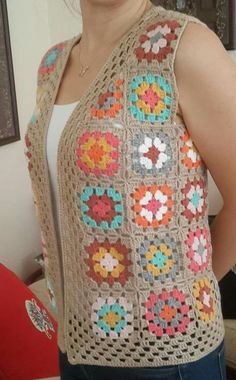 a woman is wearing a crocheted vest