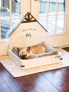 a small dog laying in its bed on the floor next to an open door and window