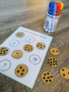 a wooden table topped with paper cut outs and markers