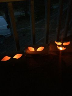 three carved pumpkins lit up in the dark