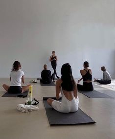 a group of people sitting on yoga mats in a room