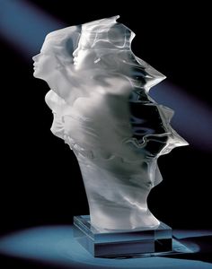 a white sculpture on a black background with light coming through the top and behind it