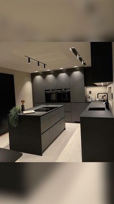 a modern kitchen with black cabinets and counter tops