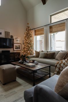 a living room filled with furniture and a christmas tree in the middle of the room