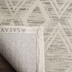 an area rug with the word avans on it and a wooden floor next to it