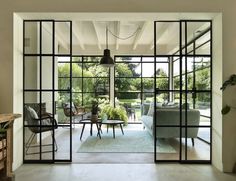 an open living room and dining area with glass doors leading to the outside patio areas