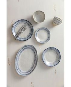 a table topped with plates and silverware on top of a white tablecloth covered floor