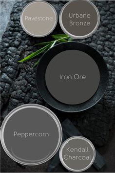 the names of different types of paint colors on a black plate and some green plants