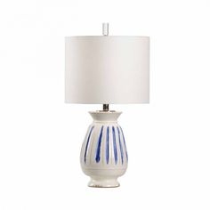 a blue and white lamp with a white shade on it's base, against a white background