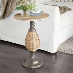 a living room with a white couch and wicker table on the floor next to it