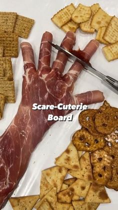 a plate with crackers, meat and cheese on it that says scare - cutie board