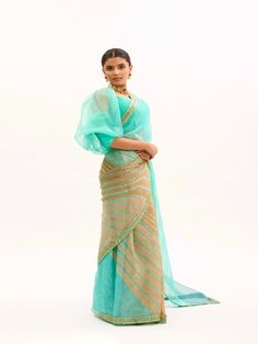 Featuring a Sea- Green Saree in Silk base with Handmade Lehariya and Gota Patti border. It is paired with matching Modal Satin Petticaot and Silk base Puff Sleeves Stitched Blouse. Fabric: Pure Silk Organza, Habutai Silk, Pure Modal Satin Lining Fabric - Cotton Color: Sea Green Embroidery & Embellishments: Gota Patti Blouse Neck: Sweetheart Fit: Fitted at bust and waist Note: The product will be delivered within 3-4 weeks of the order placed The color and size can be customized Wash Care - Dry c Traditional Pista Green Organza Pre-draped Saree, Traditional Pre-draped Saree With Sheer Dupatta For Navratri, Tissue Silk Pre-draped Saree With Zari Weaving For Reception, Pre-draped Banarasi Silk Saree With Cutdana For Reception, Traditional Pista Green Pre-draped Saree With Sheer Dupatta, Pista Green Pre-draped Saree With Zari Work For Diwali, Pista Green Organza Pre-draped Saree, Pista Green Organza Pre-draped Saree With Dupatta, Reception Zari Weaving Blouse Piece For Navratri