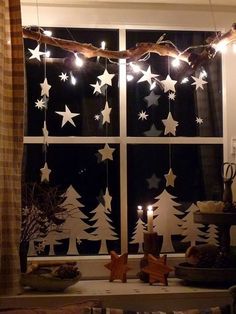 a window with christmas lights hanging from it's sides and stars on the windowsill